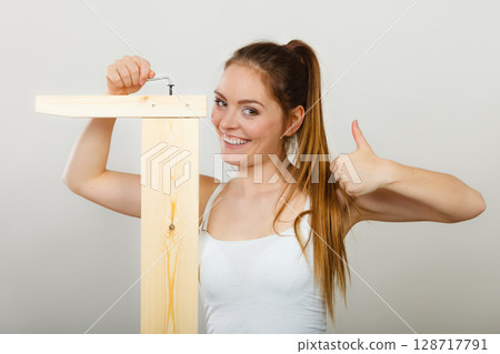 Success ful woman assembling furniture. DIY. 128717791