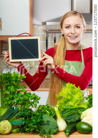 Woman having green vegetables holding board 128717880