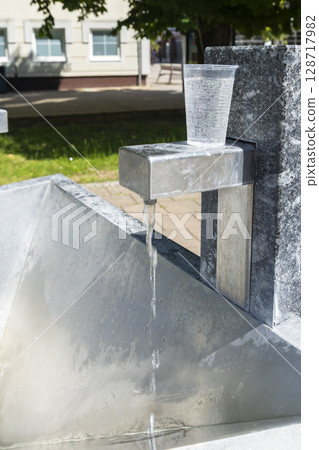 Drinking water pouring from a public fountain in Trencianske Teplice, Slovakia 128717982
