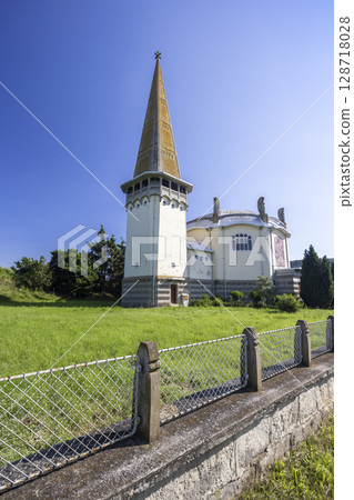Evangelical church standing in Mula, Slovakia, featuring unique architecture and rusty fence 128718028
