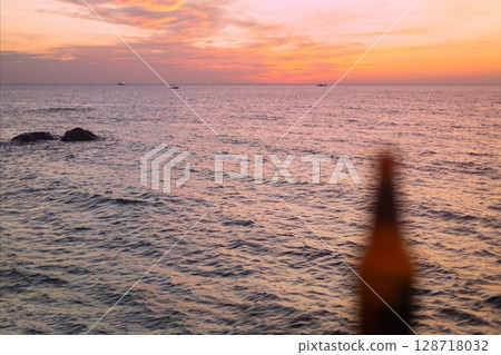 Blurred Beer Bottle on Sunset Sea Background Blurred Beer Bottle on Sunset Sea Background 128718032