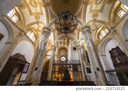 Interior of Santa Maria Square Cathedral showing columns, arches and chandelier in Baeza, Spain 128718125