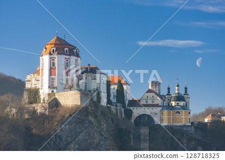 Vranov nad Dyji Chateau overlooking the Thaya river in Czech Republic with half moon in the blue sky 128718325