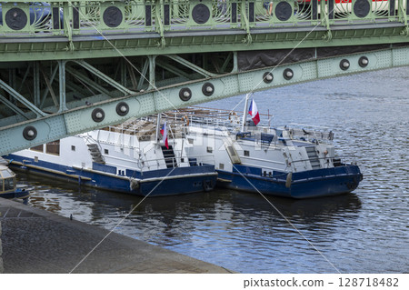 Two tour boats moored on the Vltava River under the Cechuv most bridge in Prague Two tour boats moored on the Vltava River under the Cechuv most bridge in Prague 128718482