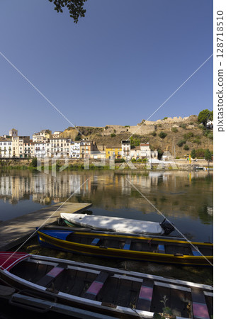 Colorful boats resting on the shore of the Ebro River in Mora d'Ebre, Catalonia Colorful boats resting on the shore of the Ebro River in Mora d'Ebre, Catalonia 128718510