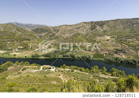 Ebro River meandering through the fertile valley near Garcia in Catalonia, Spain 128718511