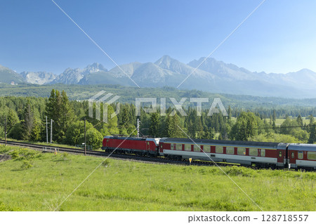 Red electric locomotive pulling passenger train in High Tatras, Slovakia 128718557