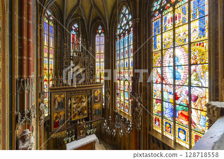 Impressive stained glass windows illuminating gothic church interior in Spissky Stvrtok, Slovakia 128718558