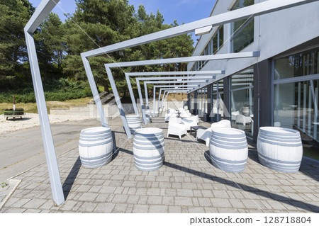 Outdoor seating area with decorative barrels and pergola providing shade in Velky Krtis, Slovakia 128718804