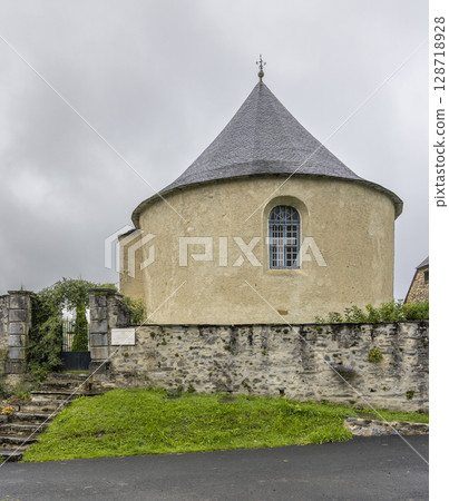 Church of Ourdis Cotdoussan showing its conical slate roof in Hautes Pyrenees, France 128718928