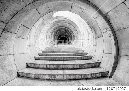 Steps lead into an endless circular tunnel creating a mysterious atmosphere with a sense of depth and intrigue Steps lead into an endless circular tunnel creating a mysterious atmosphere with a sense of depth and intrigue 128719037