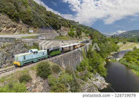 Train running along the Doux Gorges in Saint Jean de Muzols, Ardeche, France 128719079