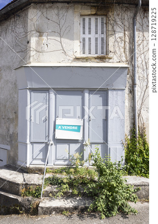 Old abandoned shop for sale with a vendre sign in french countryside Old abandoned shop for sale with a vendre sign in french countryside 128719225