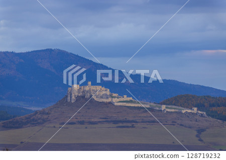 Spis Castle standing tall on a hill at dusk in Slovakia Spis Castle standing tall on a hill at dusk in Slovakia 128719232