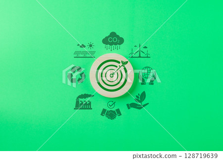Green Energy and Sustainability Concept. Wooden target icon with leaf and dart, surrounded by green energy and sustainability icons on a green background. Carbon footprint, environmental conservation, 128719639