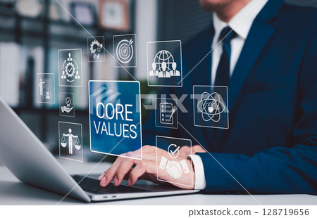Business Core Values and Corporate Culture Concept. Businessman working on laptop with core values icons, ethics, teamwork, integrity, corporate mission, organizational culture and business principles 128719656