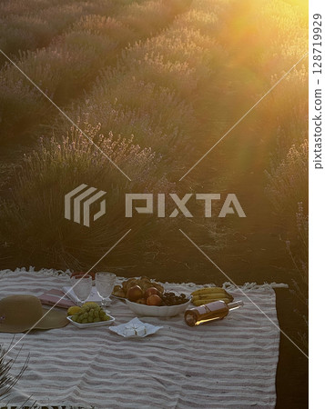 Sunset Picnic in Lavender Field with Wine and Fruits Sunset Picnic in Lavender Field with Wine and Fruits 128719929