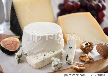 Board of different cheeses with nuts, figs, grapes and wine Board of different cheeses with nuts, figs, grapes and wine 128720081