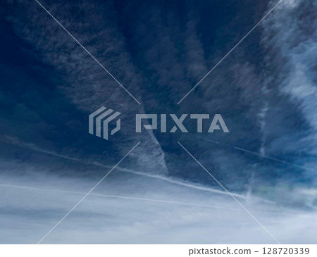 The bright blue sky is calm and peaceful, with a few white clouds drifting gently 128720339