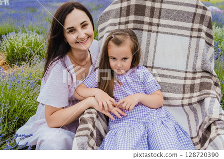 A girl in a beautiful purple dress sits in a rocking chair 128720390