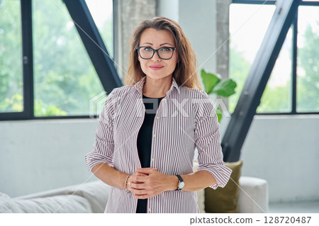 Portrait of middle-aged confident business woman looking at camera Portrait of middle-aged confident business woman looking at camera 128720487