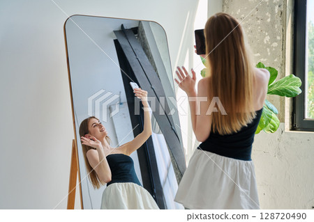 Smiling young teenage female taking selfie photo on smartphone 128720490