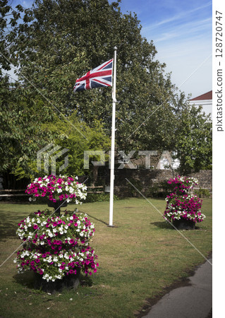 Union flag at centre of village with flower displays 128720747