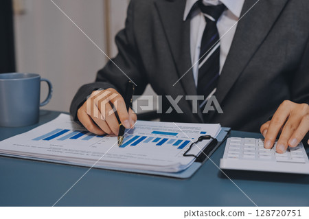 Business financing accounting banking concept. Business woman hand doing finances and calculate on desk about cost at home office. Woman working on desk with using calculator, finance accounting. Business financing accounting banking concept. Business woman hand doing finances and calculate on desk about cost at home office. Woman working on desk with using calculator, finance accounting. 128720751