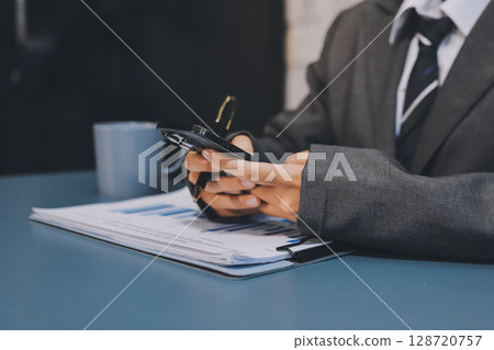 Asian business man using cell phone. Having Conversation, typing sms or presenting. 128720757