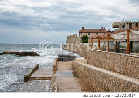 Medieval walls and modern restaurant by Adriatic Sea. Novigrad, Croatia Medieval walls and modern restaurant by Adriatic Sea. Novigrad, Croatia 128720814