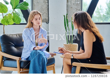 Young woman in psychology session talking with professional therapist, mental specialist. 128720816