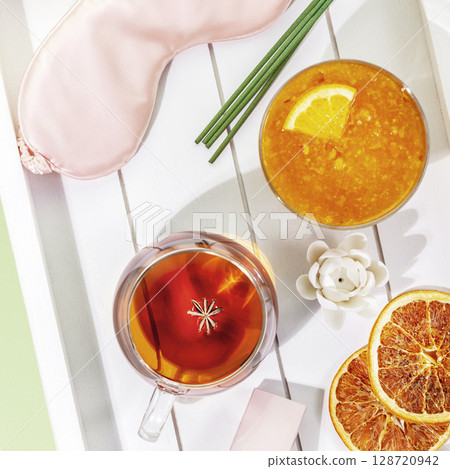 Sleep care banner with mask for sleep, cup of tea, orange jam, aroma sticks on a wooden tray. Concept of relax at home, self care and me time. Insomnia or depression treatment, sleepless nights 128720942