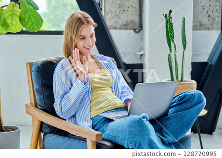 Young woman using laptop for video call, online chat conference sitting at home Young woman using laptop for video call, online chat conference sitting at home 128720995