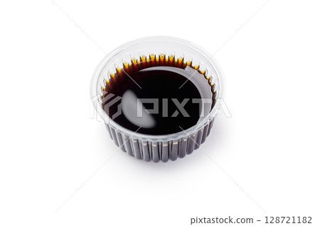 Soy sauce filling a small plastic portion cup on white background 128721182