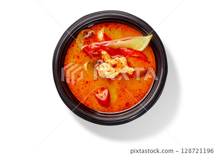 Tom yam soup with chicken and lime in black bowl on white background Tom yam soup with chicken and lime in black bowl on white background 128721196