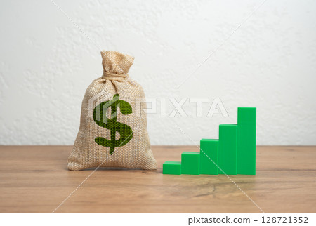 Dollar money bag and green growth chart. Economic expansion, successful investments, and upward trends in business performance. Growing profitability, investment returns, growth indicators. 128721352