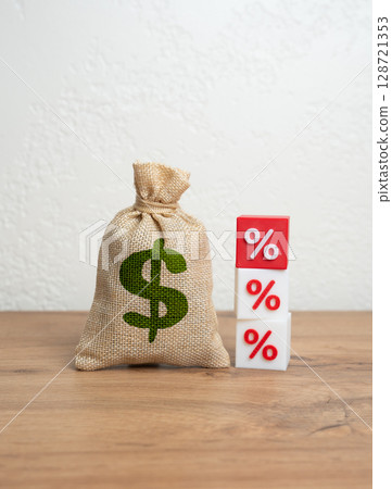 Dollar money bag and red percentage. Rising loan rates or falling investment returns. Financial loss, inflation, or increased tax pressure. Economic risk, fiscal policy tension, or budget imbalance. 128721353