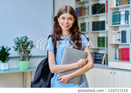 Portrait of teenage beautiful girl high school student posing in library classroom 128721520