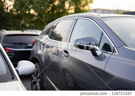 A row of cars parked outdoors, showcasing modern automotive design and urban transportation. A row of cars parked outdoors, showcasing modern automotive design and urban transportation. 128721587