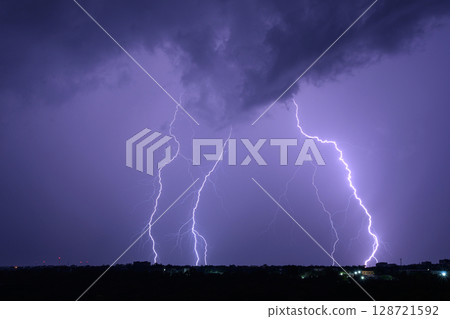Multiple lightning bolts striking during dramatic night thunderstorm. Multiple lightning bolts striking during dramatic night thunderstorm. 128721592