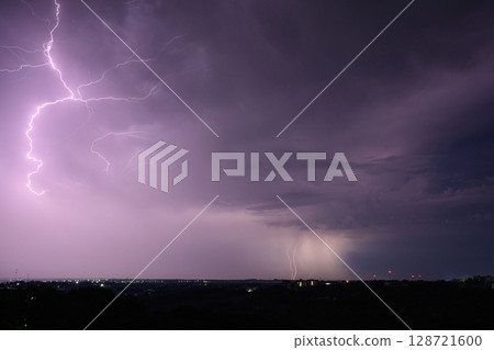 Lightning storm with branching bolts over night city skyline. 128721600