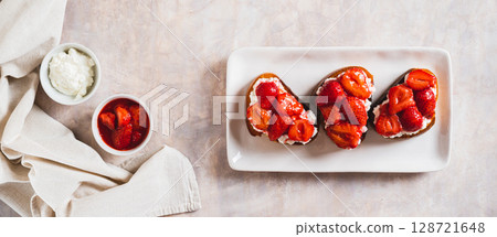 Sandwiches with cream cheese and fried strawberries on a plate on a table top view web banner Sandwiches with cream cheese and fried strawberries on a plate on a table top view web banner 128721648