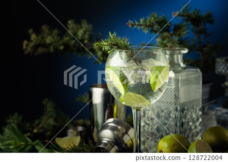Cocktail gin and tonic with ice and lime slices. 128722004