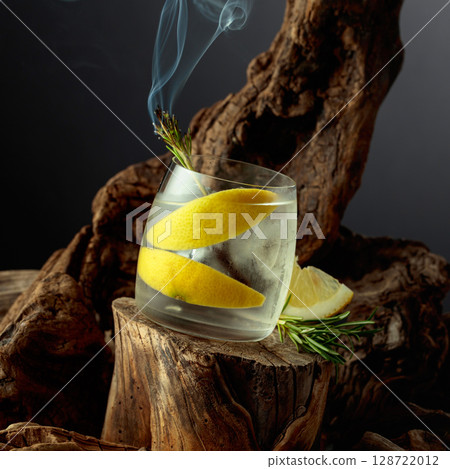 Cocktail gin and tonic with lemon slices and sprig of rosemary. Cocktail gin and tonic with lemon slices and sprig of rosemary. 128722012