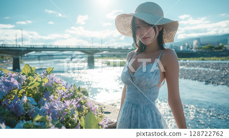 盛夏時節，河岸上一位戴著草帽、穿著洋裝的女子 128722762