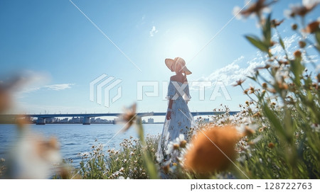 盛夏時節，河岸上一位戴著草帽、穿著洋裝的女子 128722763