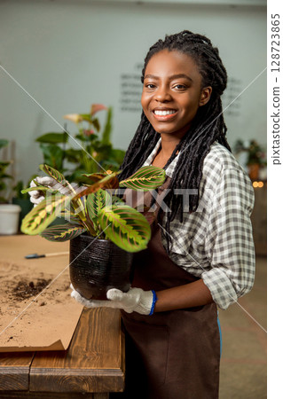 Young woman working in the flower shop and feeling good Young woman working in the flower shop and feeling good 128723865