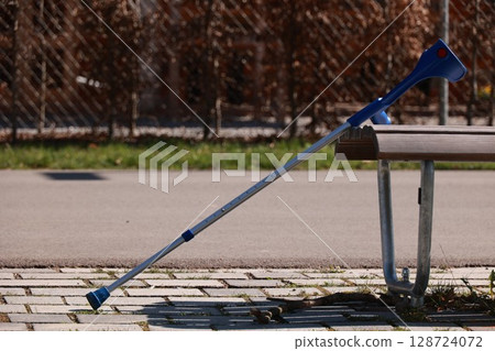 A blue cane is leaning against a bench A blue cane is leaning against a bench 128724072
