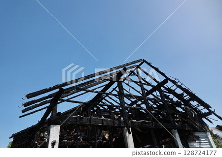 A house with a black roof and a blue sky in the background 128724177