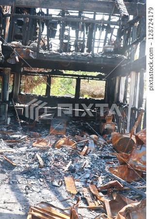 A burned down building with a lot of debris and ash A burned down building with a lot of debris and ash 128724179